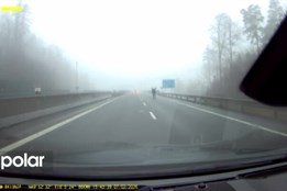 Nepochopitelný hazard se životem. Chodec v černém v mlze uprostřed pruhu rychlostní silnice